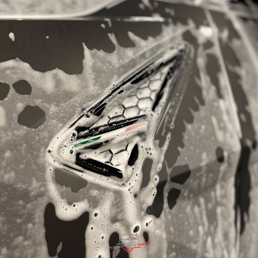 Mousse de lavage sur une carrosserie foncée