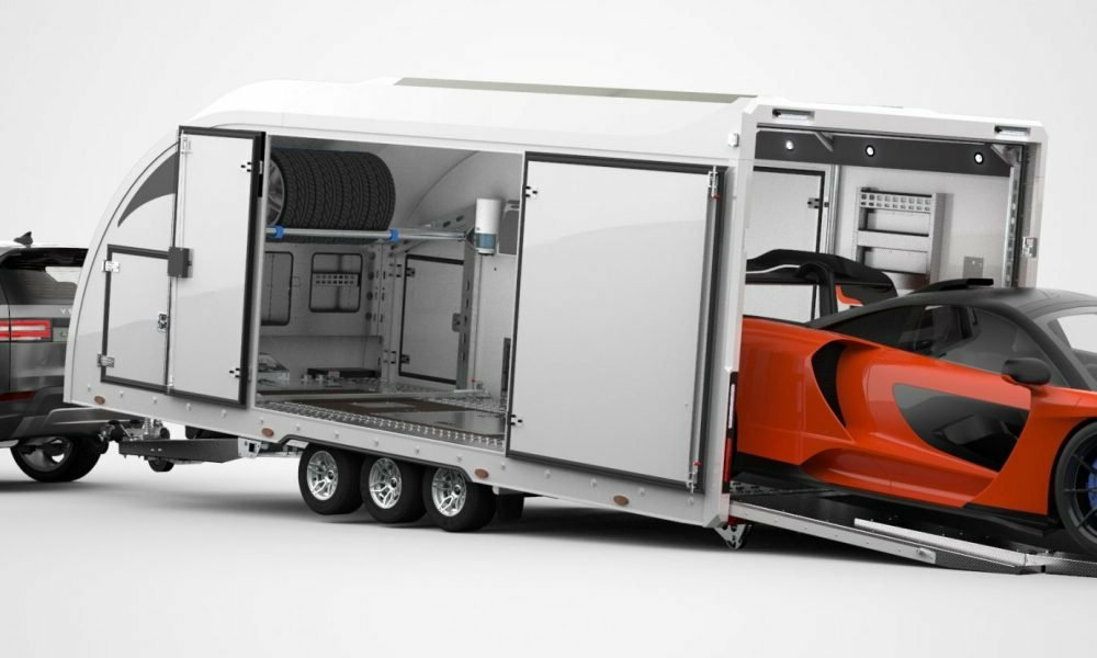 Supercar orange chargée par la rampe arrière d une remorque fermée haut de gamme attelée à un SUV